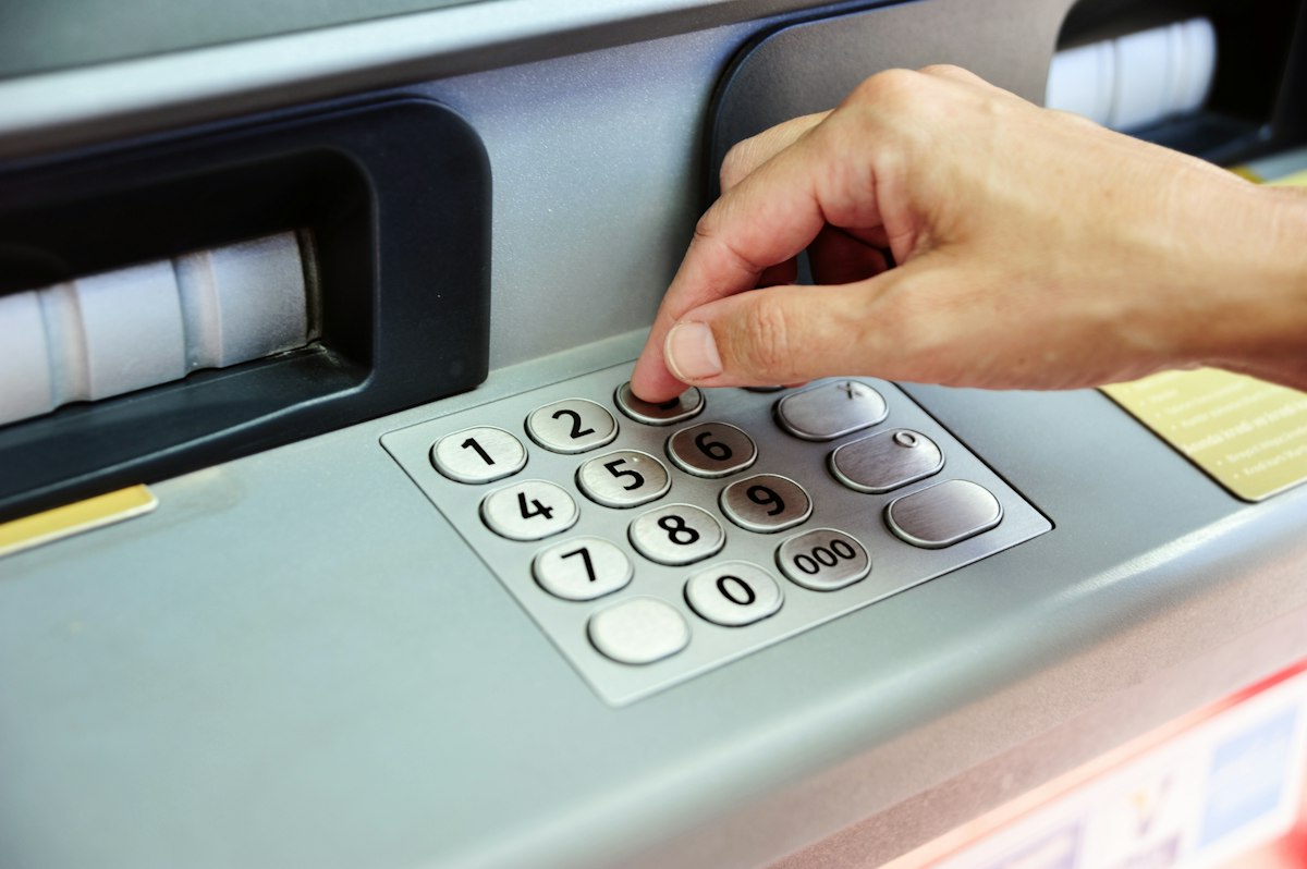 Japonya'da Banka Hesabı Nasıl Açılır? Yabancılar İçin Rehber 3 ATM ekraninda PIN girisi yapan el